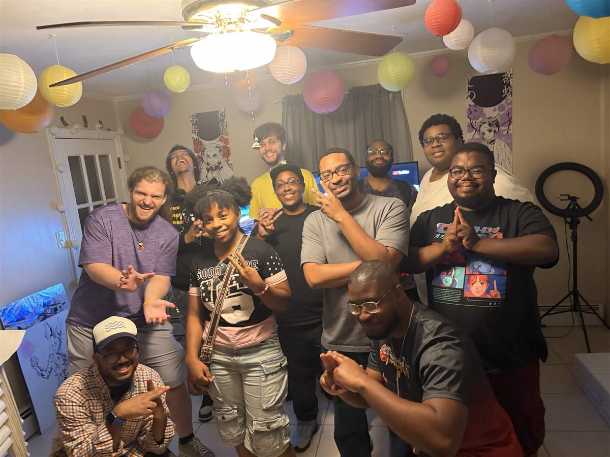 Club members posing together beneath colorful paper lanterns and anime posters