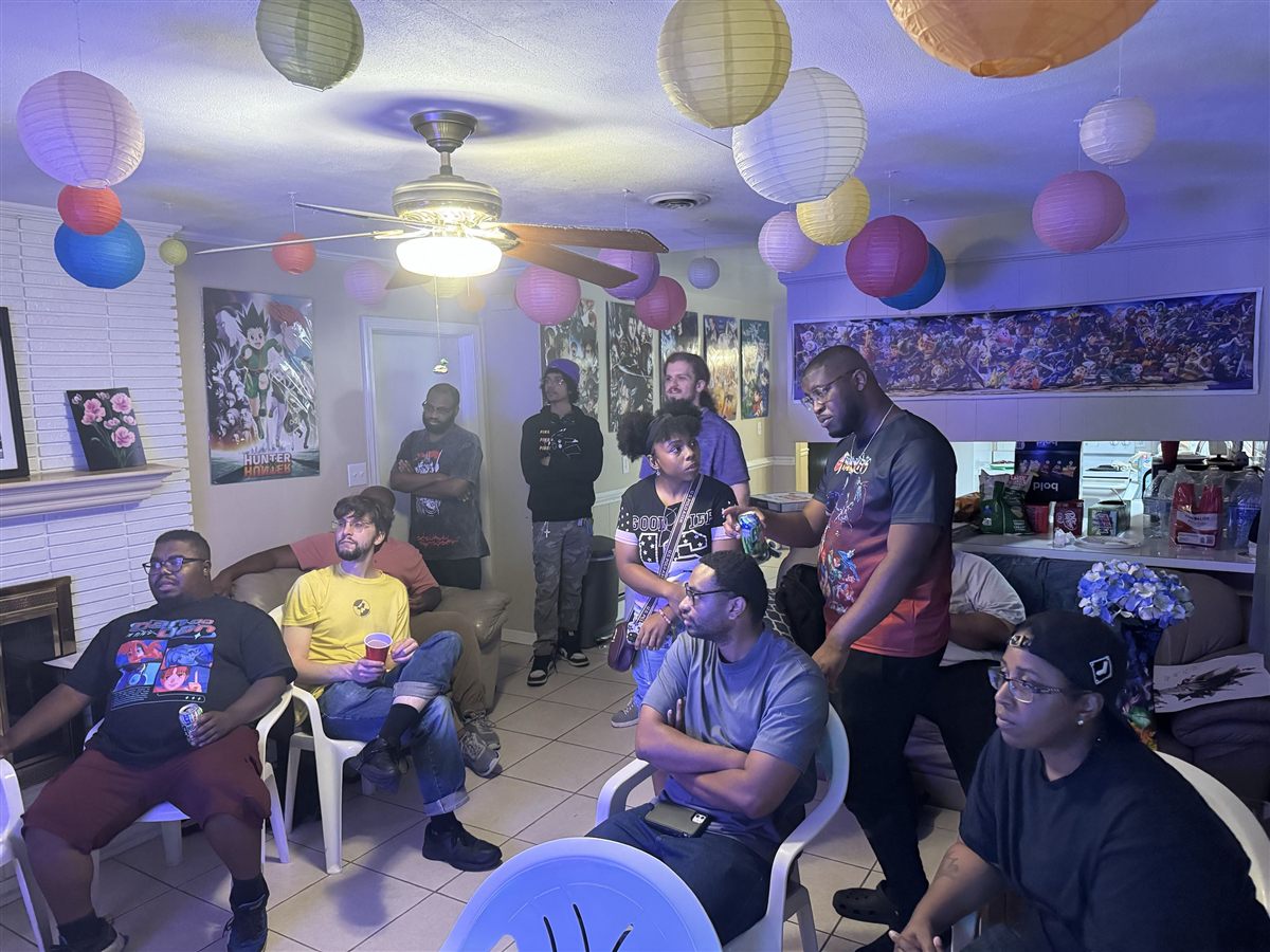 Club members hanging out in a room decorated with anime posters and paper lanterns